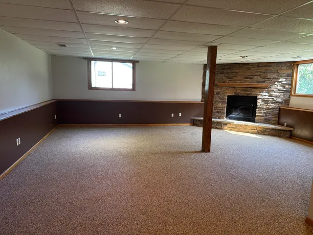 a view of an empty room with a fireplace and a window