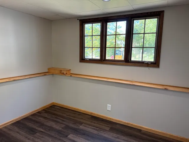 a view of a small space with wooden floor and a window