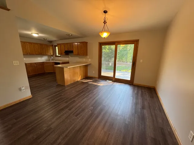 a kitchen with counter top space stainless steel appliances and wooden floor