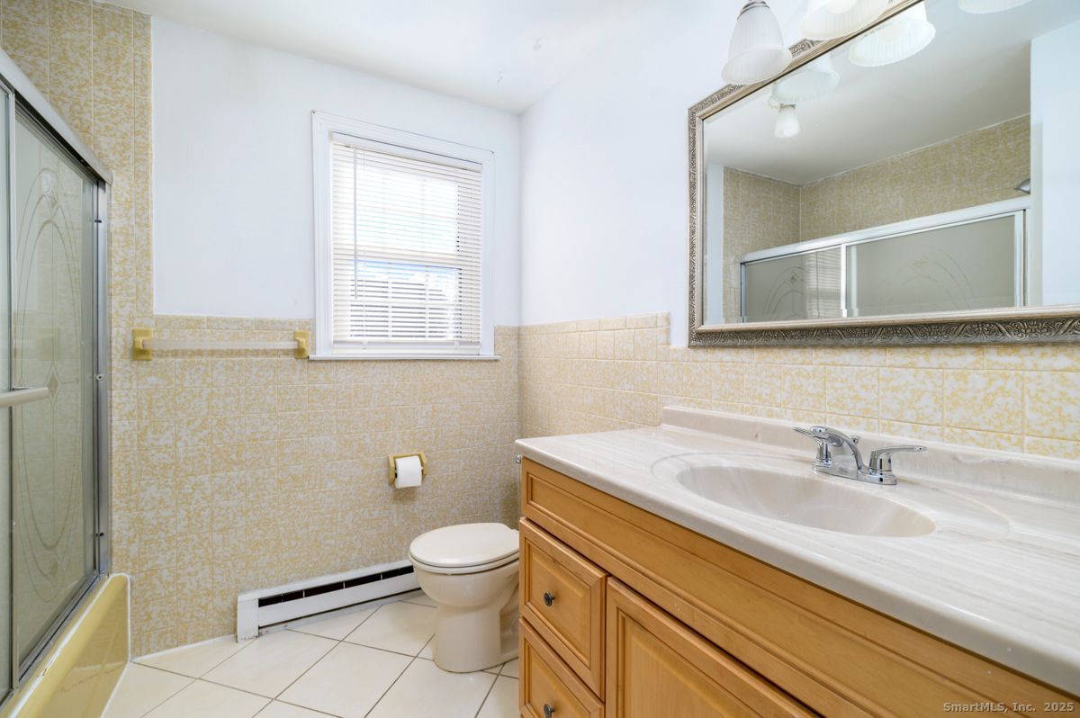 200 Frederick Street, Unit 2 Stamford, CT 06902 - Photo 10 of 13 a bathroom with a granite countertop toilet sink and mirror