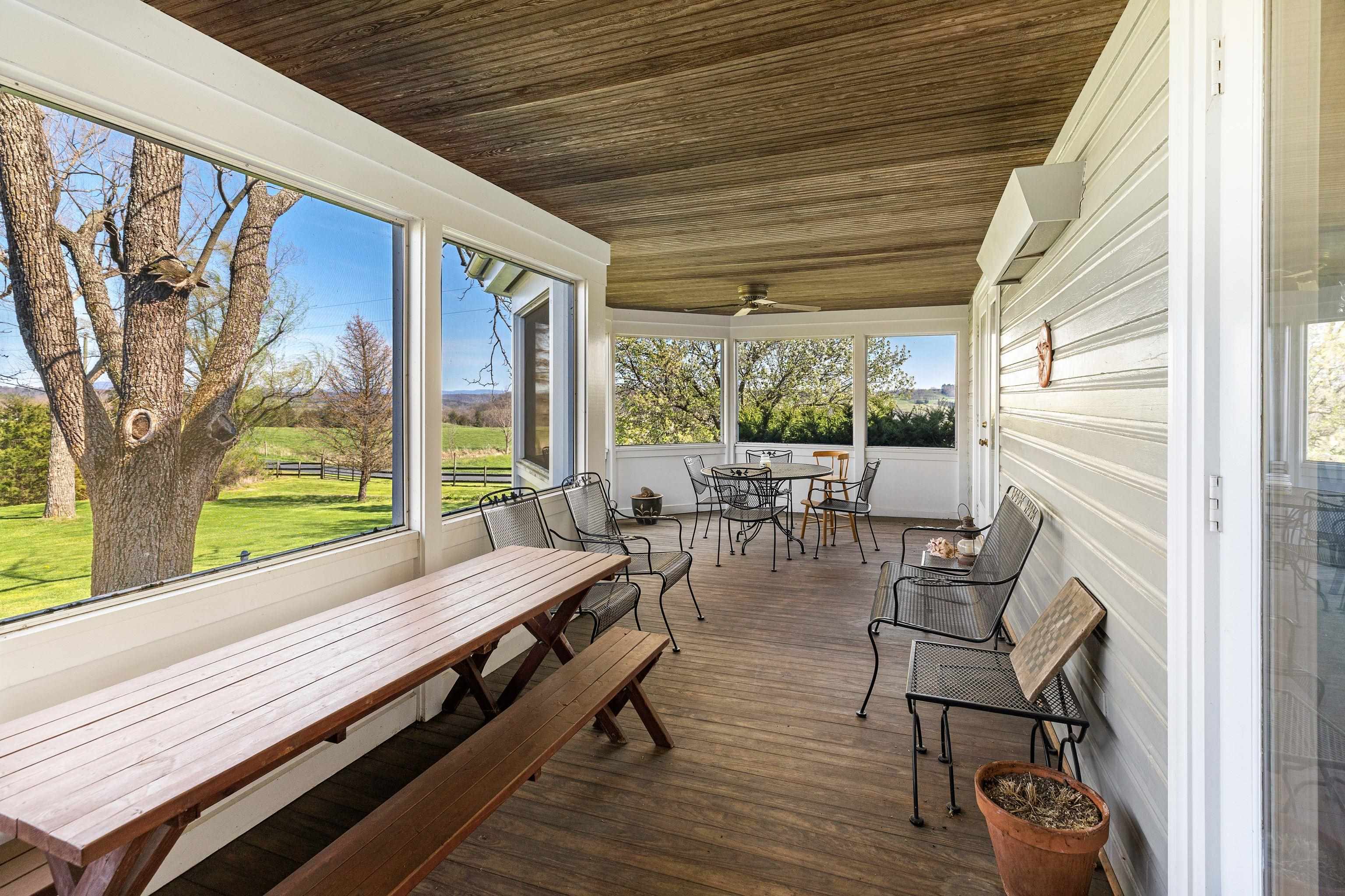 191 Middle River Road Staunton, VA 24401 - Photo 17 of 55 a view of a patio with table and chairs and floor to ceiling window with wooden floor