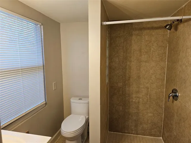 a white toilet sitting next to a shower