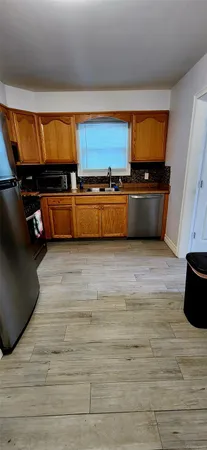 a view of kitchen with stainless steel appliances a sink and cabinets