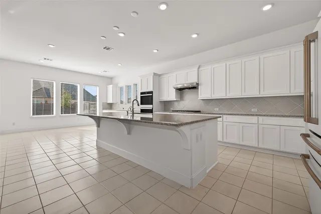 a kitchen with stainless steel appliances granite countertop a refrigerator sink and cabinets