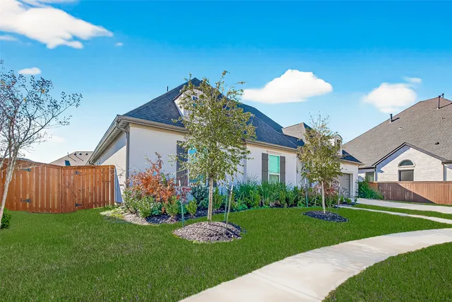 a front view of a house with a garden and plants