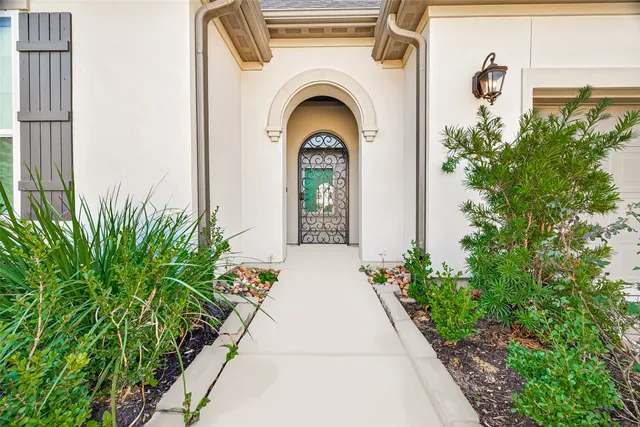 a view of a house with potted plants next to a road