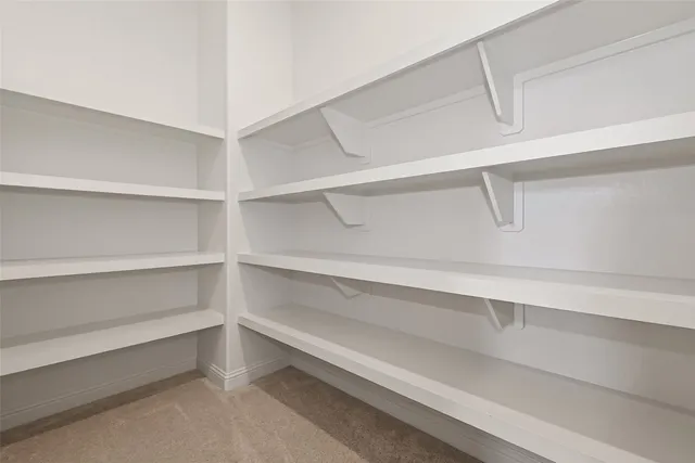 a view of an empty room with a floor to ceiling window and front door