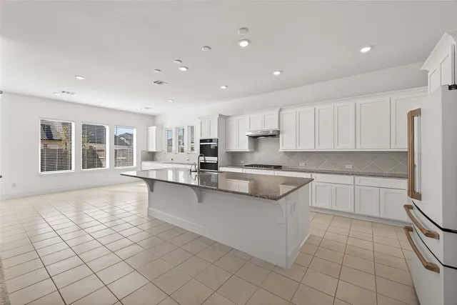 a large white kitchen with cabinets