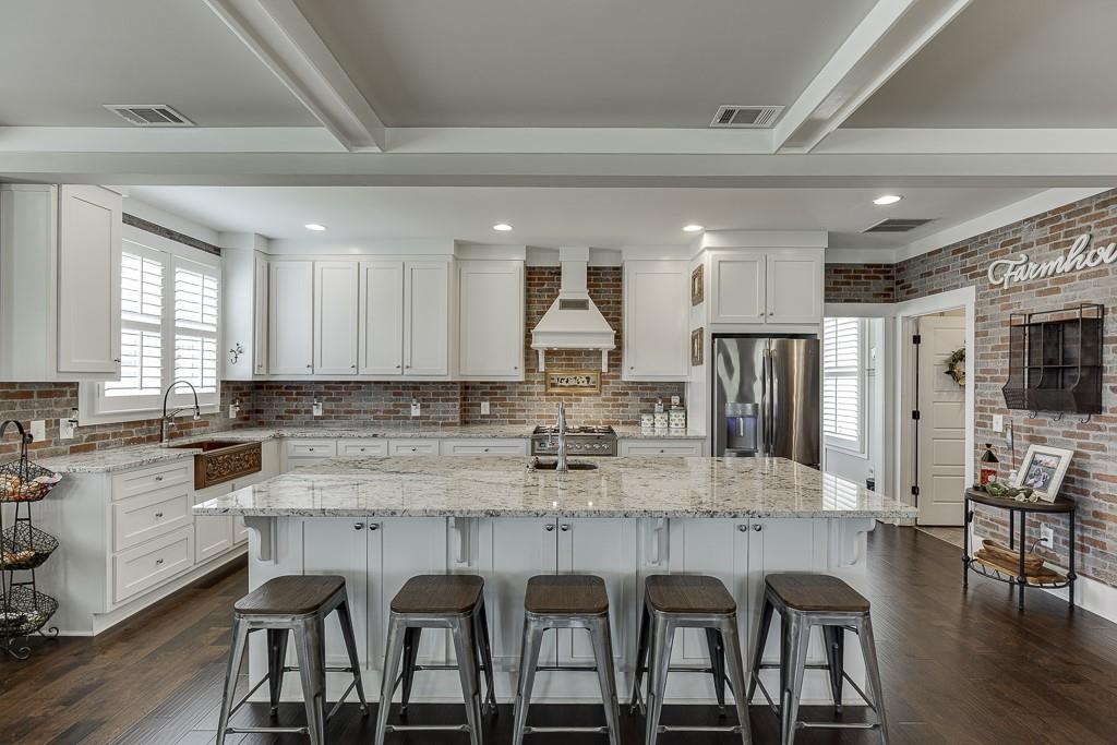 890 Smith Mill Road Winder, GA 30680 - Photo 13 of 95 a kitchen with stainless steel appliances granite countertop a table chairs sink and cabinets