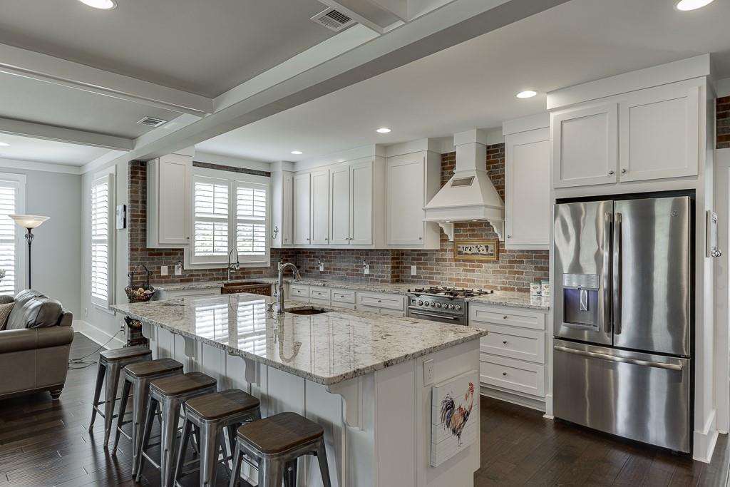 890 Smith Mill Road Winder, GA 30680 - Photo 14 of 95 a kitchen with stainless steel appliances granite countertop a table chairs refrigerator and sink