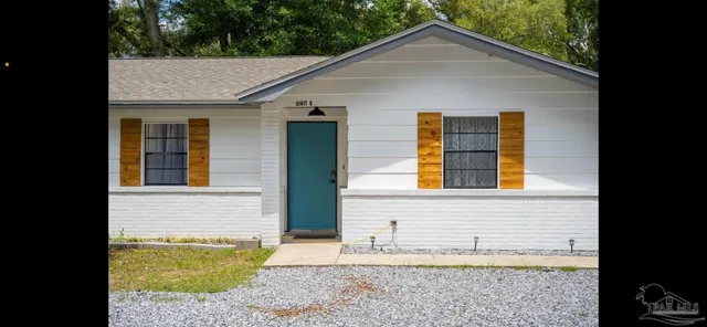 a view of a backyard with table and chairs and potted plants