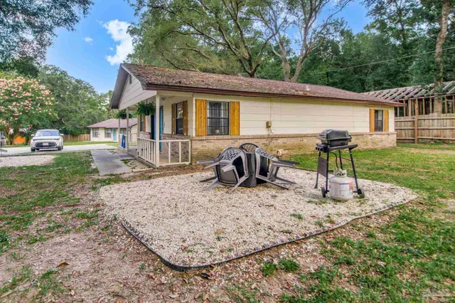 an aerial view of a house with a yard and trees all around