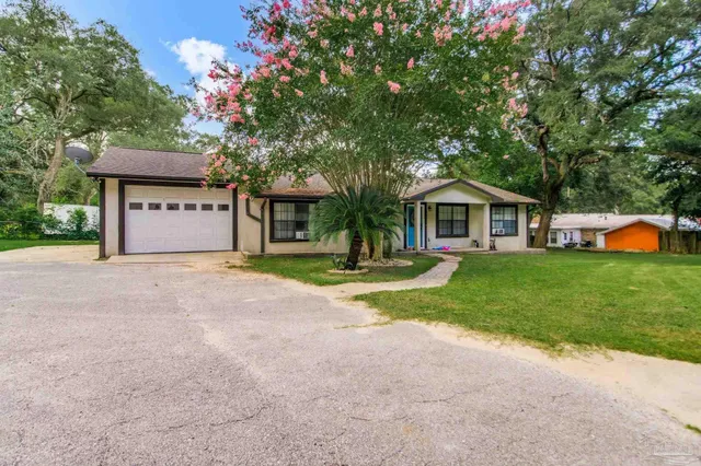 a view of a house with backyard and sitting area