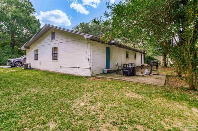 a backyard of a house with table and chairs