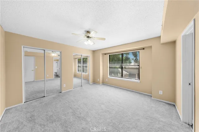 an empty room with windows and closet