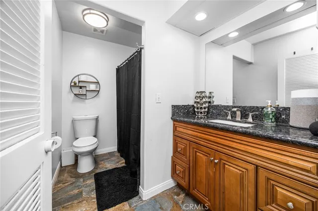 a bathroom with a sink a toilet and a mirror