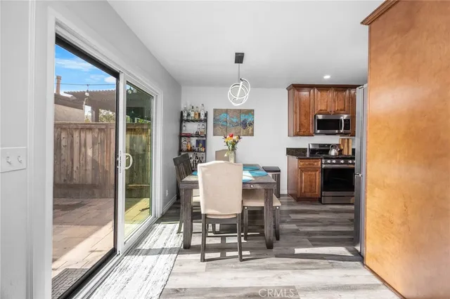 a dining room with wooden floor and large window