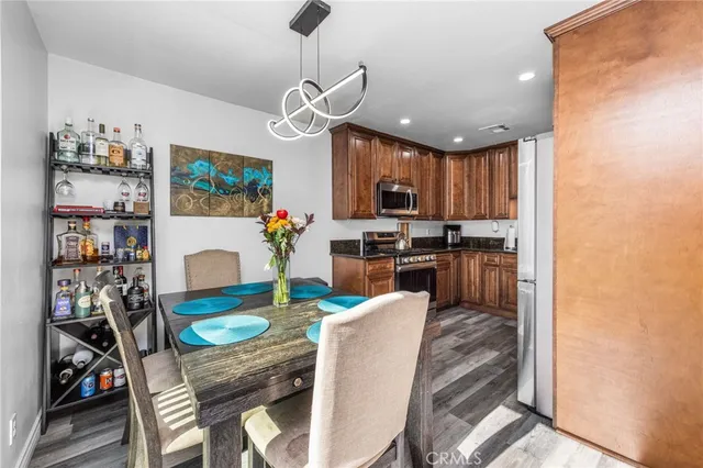 a view of a dining room with furniture a kitchen and chandelier