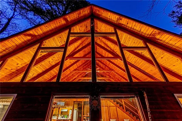 a backyard of a house with wooden deck and a large tree