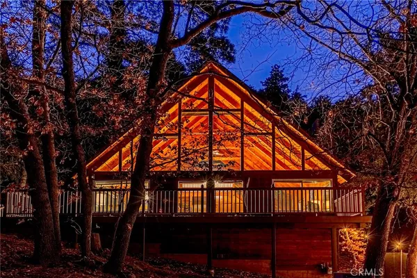 a backyard of a house with large trees and plants