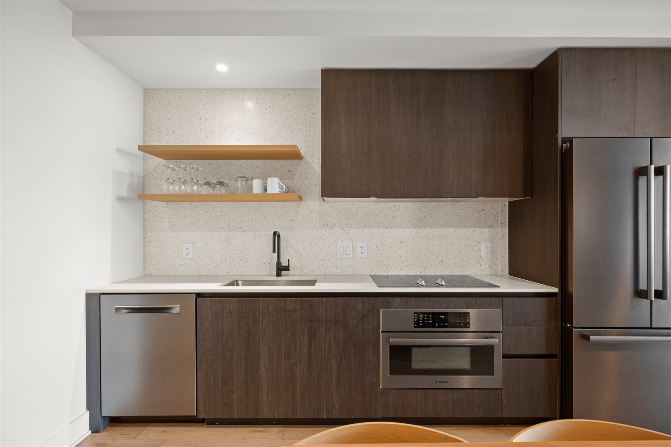48 East Avenue, Unit 2807 Austin, TX 78701 - Photo 2 of 23 The quartz countertops shine alongside modern cabinetry, with open shelving adding an effortlessly chic touch, perfect for showcasing your favorite kitchen essentials