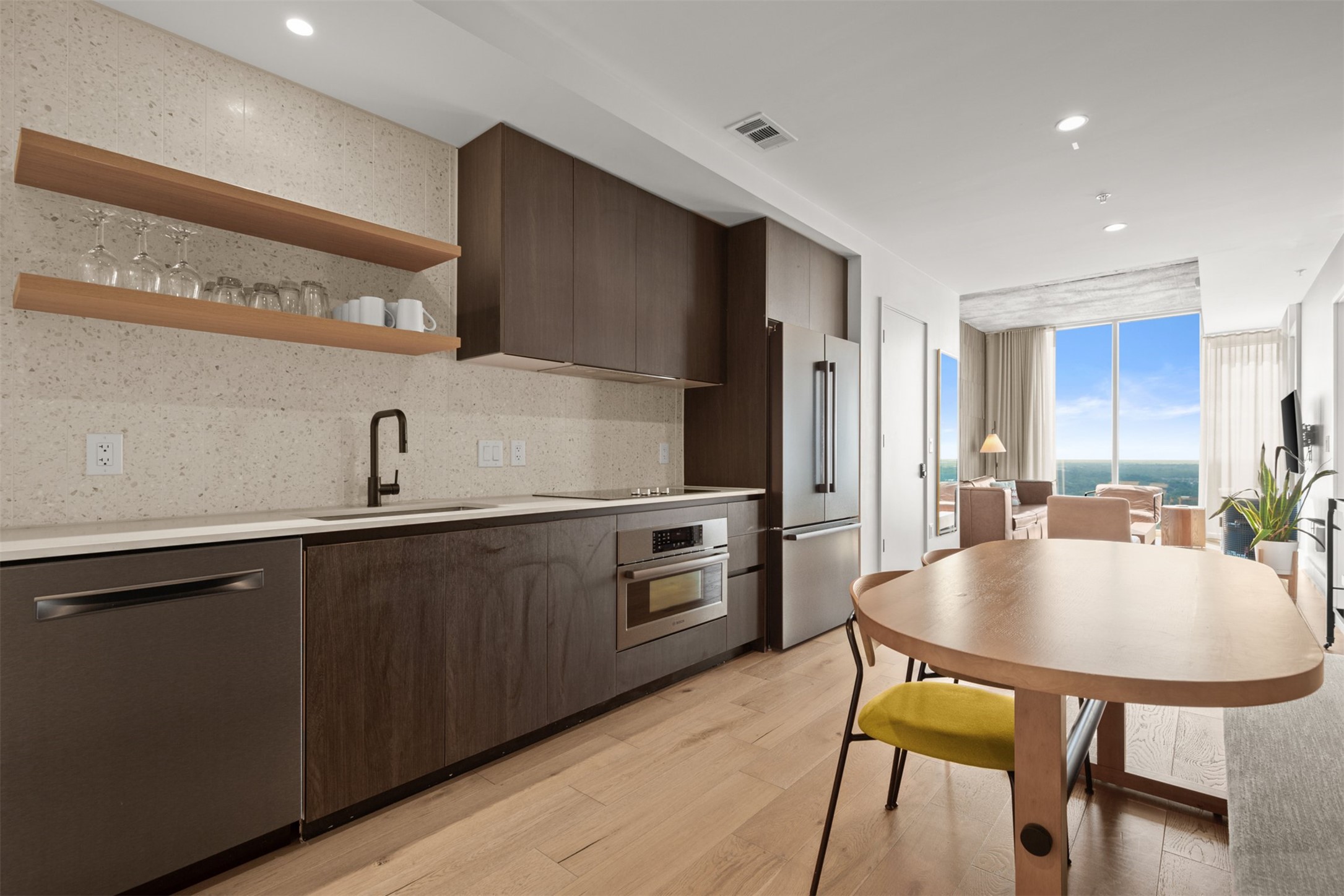 48 East Avenue, Unit 2807 Austin, TX 78701 - Photo 3 of 23 Stainless steel appliances paired with a tile backsplash elevate the space, turning everyday meals into something special