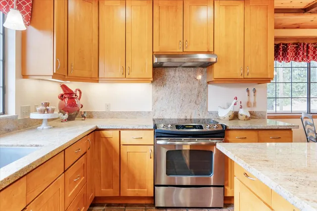 a kitchen with granite countertop a sink stainless steel appliances and cabinets
