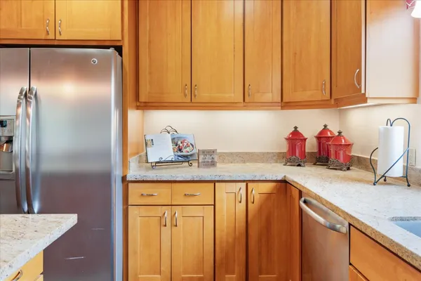 a kitchen with granite countertop a sink stainless steel appliances and cabinets