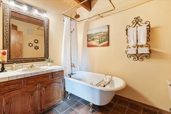 a bathroom with a tub sink and mirror