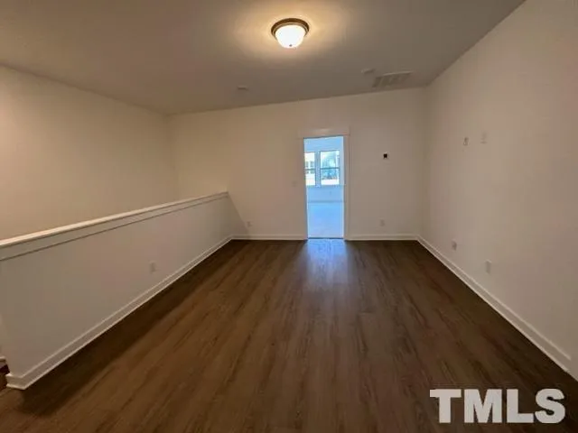 a view of a room with wooden floor and window