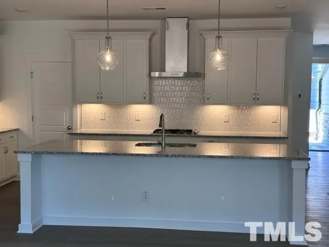 a kitchen with stainless steel appliances granite countertop a sink a stove and a refrigerator