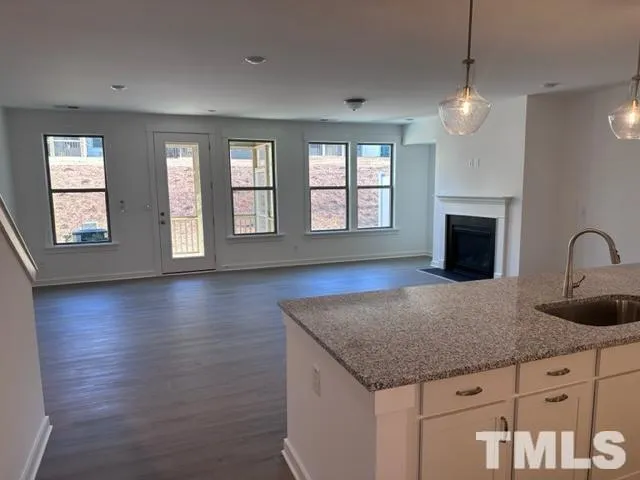 a kitchen with granite countertop a stove and a wooden floors