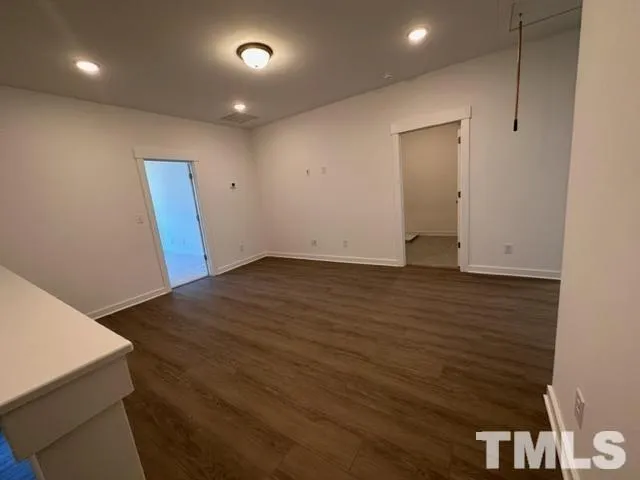 an empty room with wooden floor and entrance