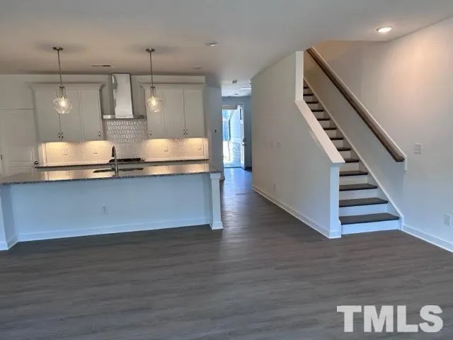 a view of a kitchen with wooden floor and staircase