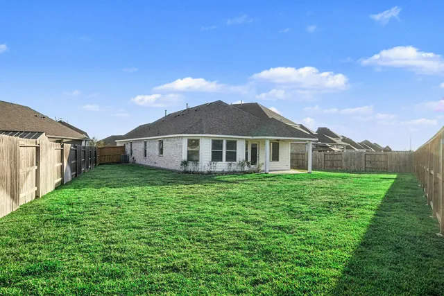 a view of a house with a big yard and large trees