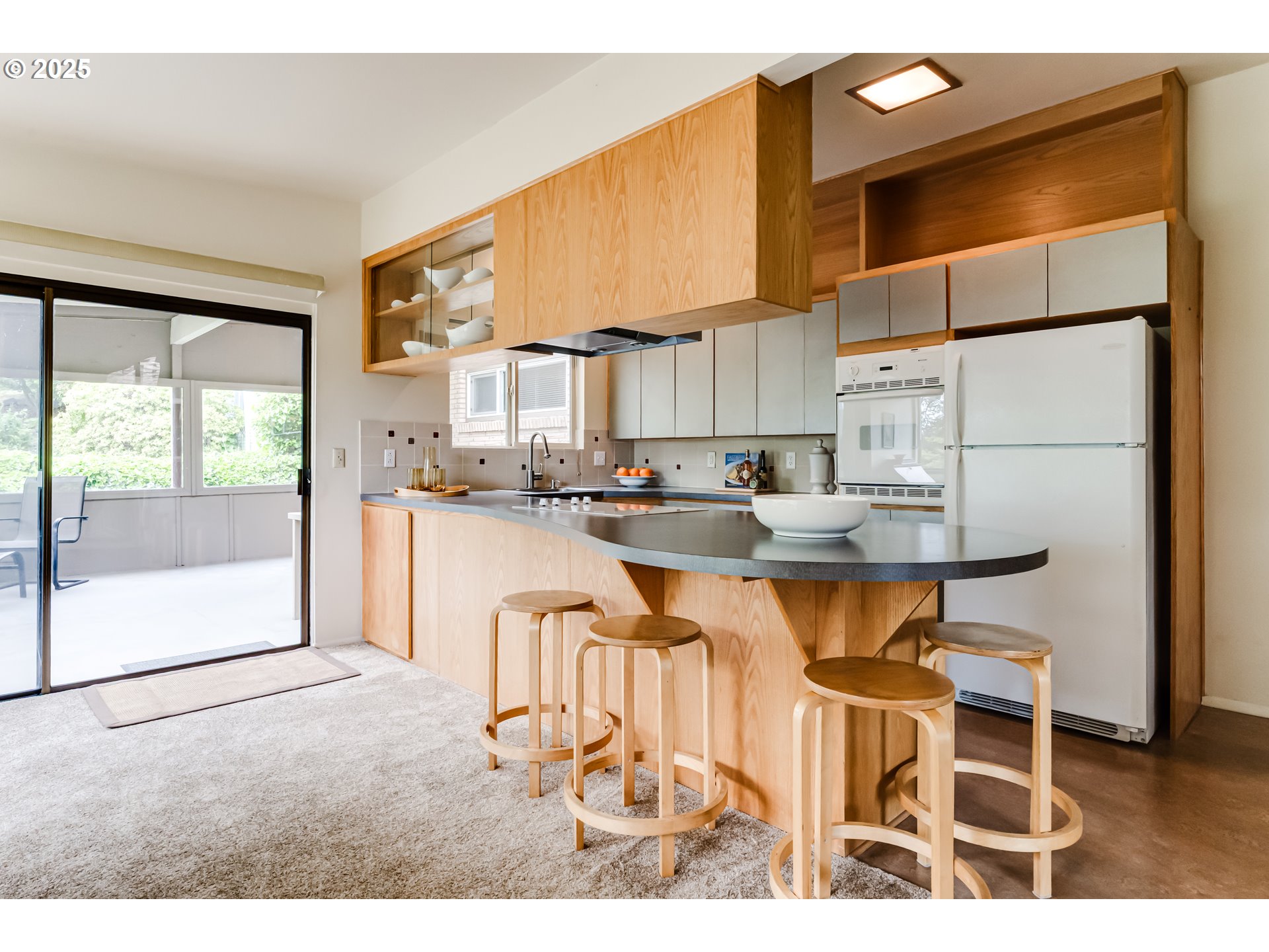 495 West 27th Avenue Eugene, OR 97405 - Photo 12 of 48 a kitchen with a table chairs refrigerator and cabinets