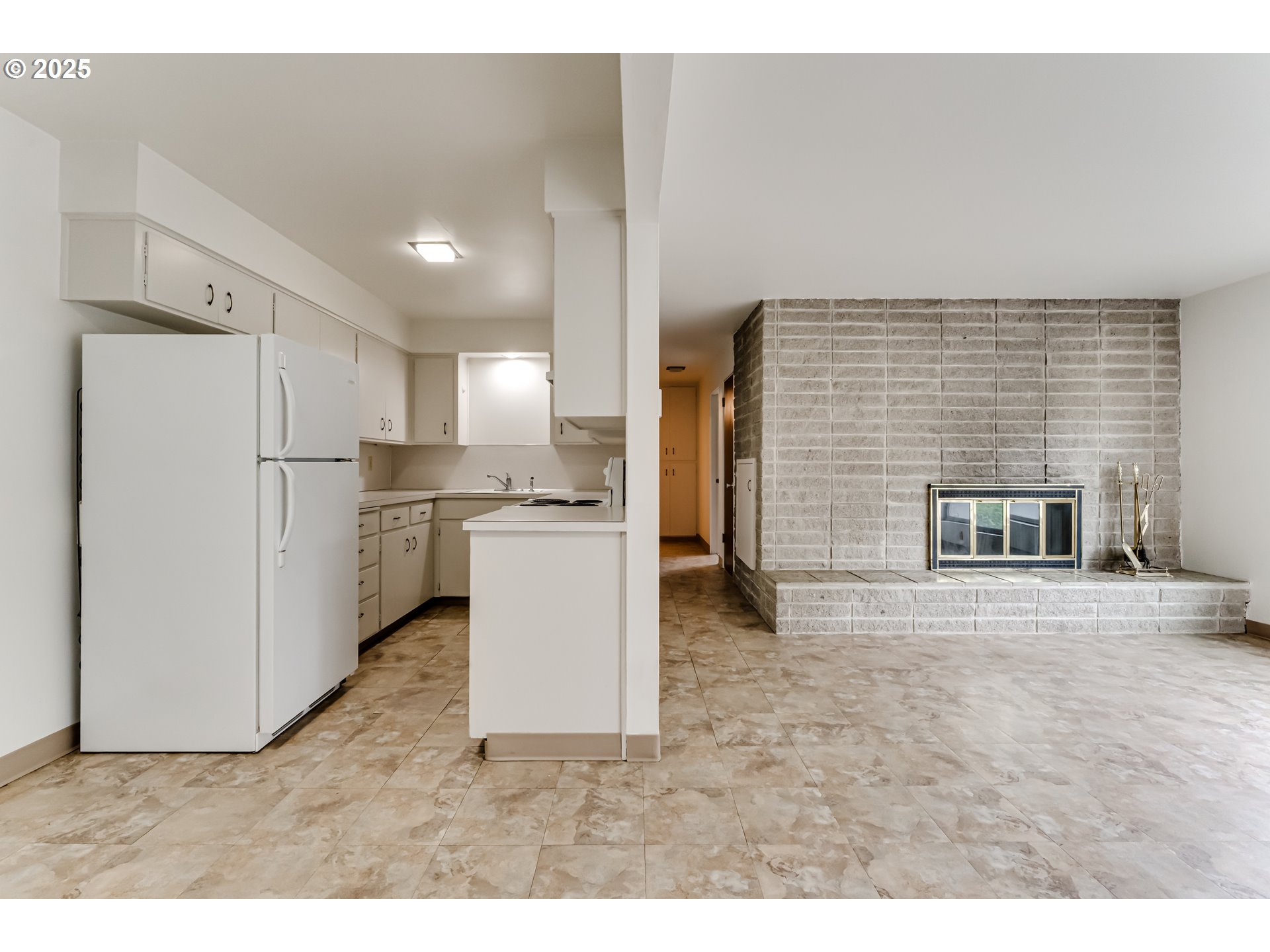 495 West 27th Avenue Eugene, OR 97405 - Photo 39 of 48 a view of a kitchen with refrigerator and white cabinets