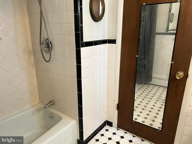a bathroom with a tub sink and mirror