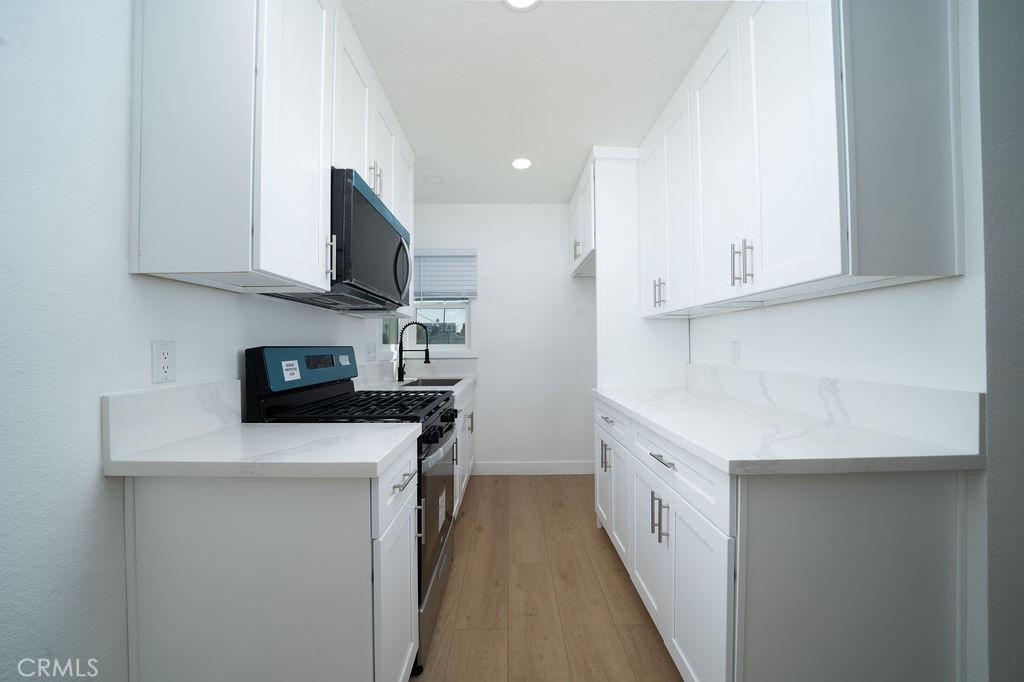 1050 Cedar Avenue Long Beach, CA 90813 - Photo 4 of 8 a kitchen with stainless steel appliances a sink dishwasher stove refrigerator and microwave