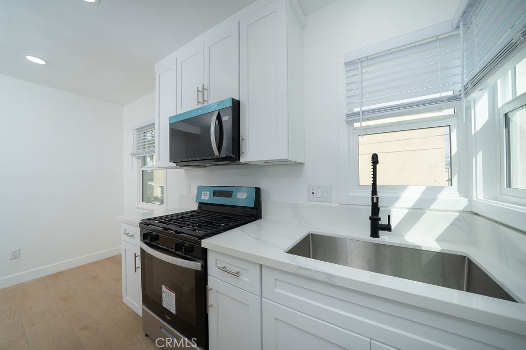 1050 Cedar Avenue Long Beach, CA 90813 - Photo 5 of 8 a kitchen with granite countertop a sink and a stove top oven