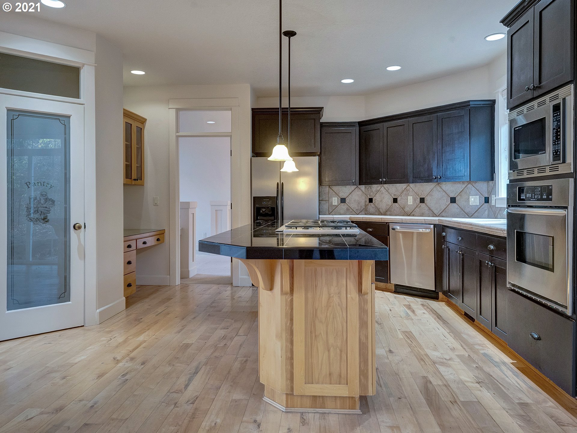 10248 Southeast Nicole Loop Happy Valley, OR 97086 - Photo 10 of 32 a kitchen with stainless steel appliances granite countertop a sink a stove a refrigerator and island with wooden floor