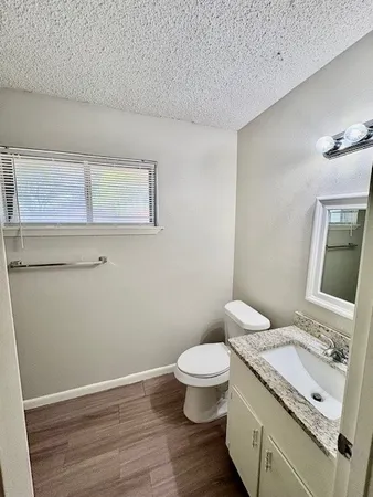 a bathroom with a granite countertop toilet and sink