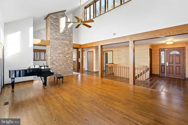 a view of a hallway with wooden floor and furniture