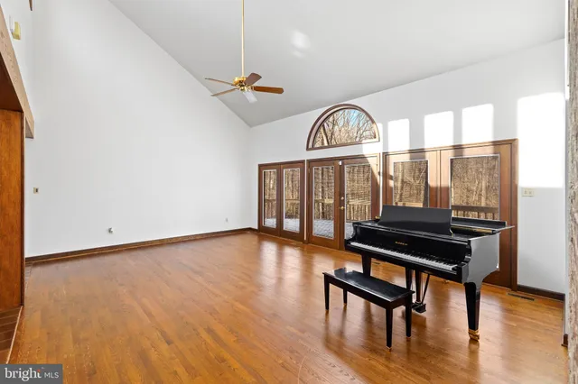 a view of a livingroom with furniture a ceiling fan and wooden floor