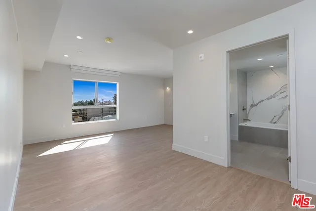 an empty room with wooden floor and a fireplace