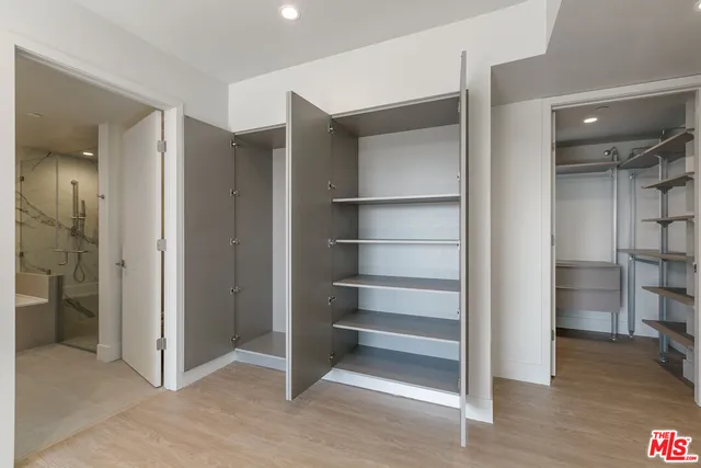 a view of walk in closet with empty racks