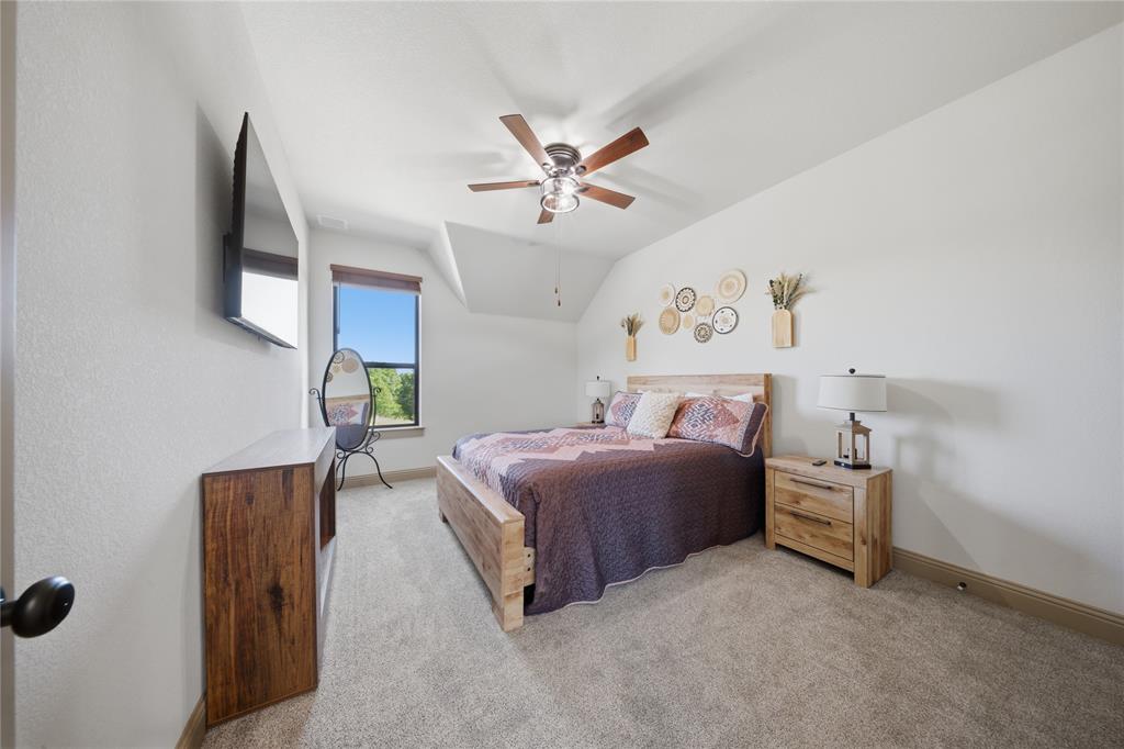 958 Cedar Mills Road Gordonville, TX 76245 - Photo 32 of 40 a bedroom with a bed and a chandelier