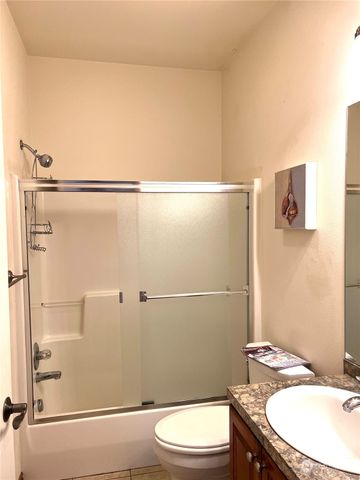 a bathroom with a granite countertop sink mirror vanity and toilet