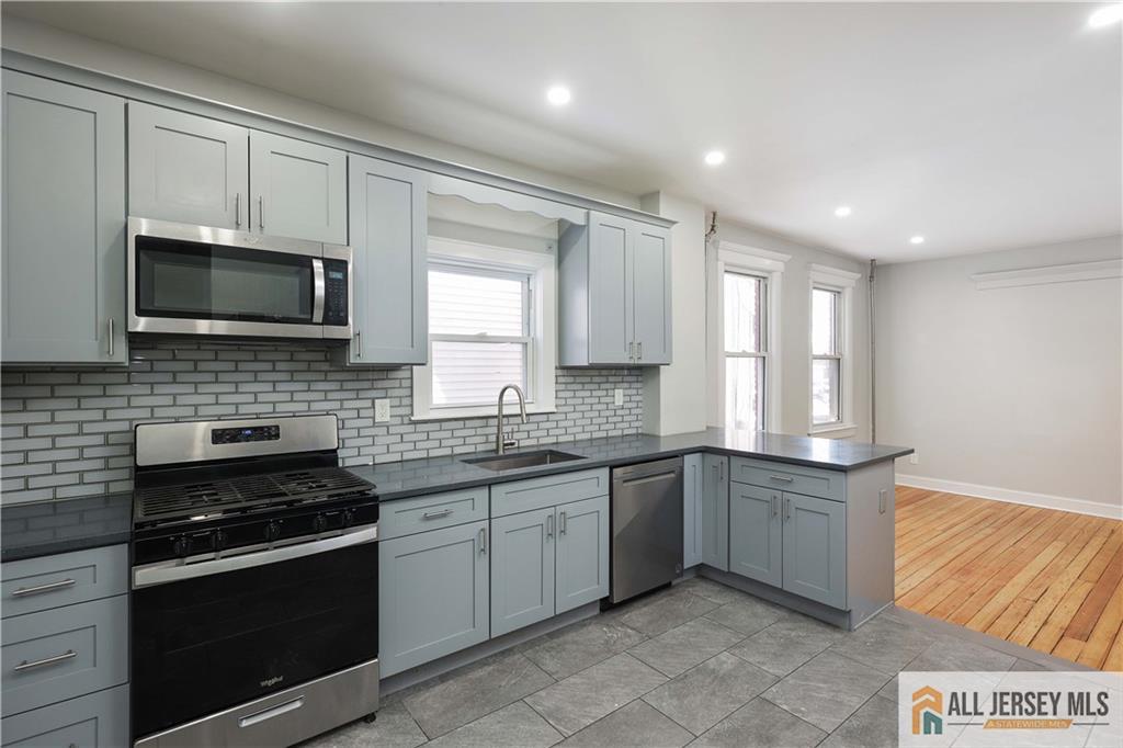 344 Market Street Perth Amboy, NJ 08861 - Photo 14 of 31 a kitchen with stainless steel appliances granite countertop a stove sink microwave and cabinets