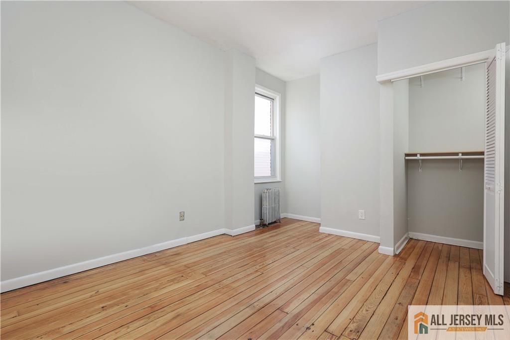 344 Market Street Perth Amboy, NJ 08861 - Photo 20 of 31 an empty room with wooden floor and windows